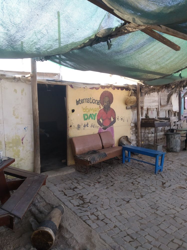 Eine einfache Hütte in Namibia mit einem Graffiti zum International Women's Day.