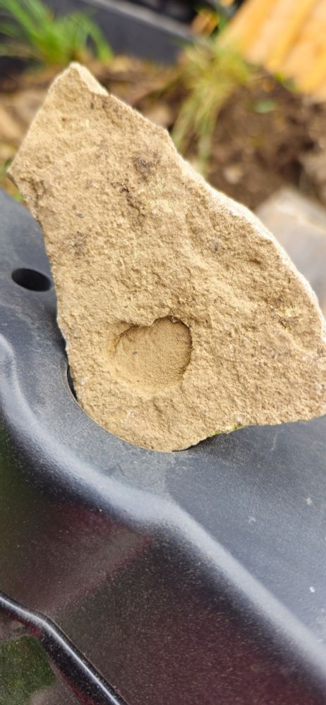 Sandstone colored rock with a carved heart.