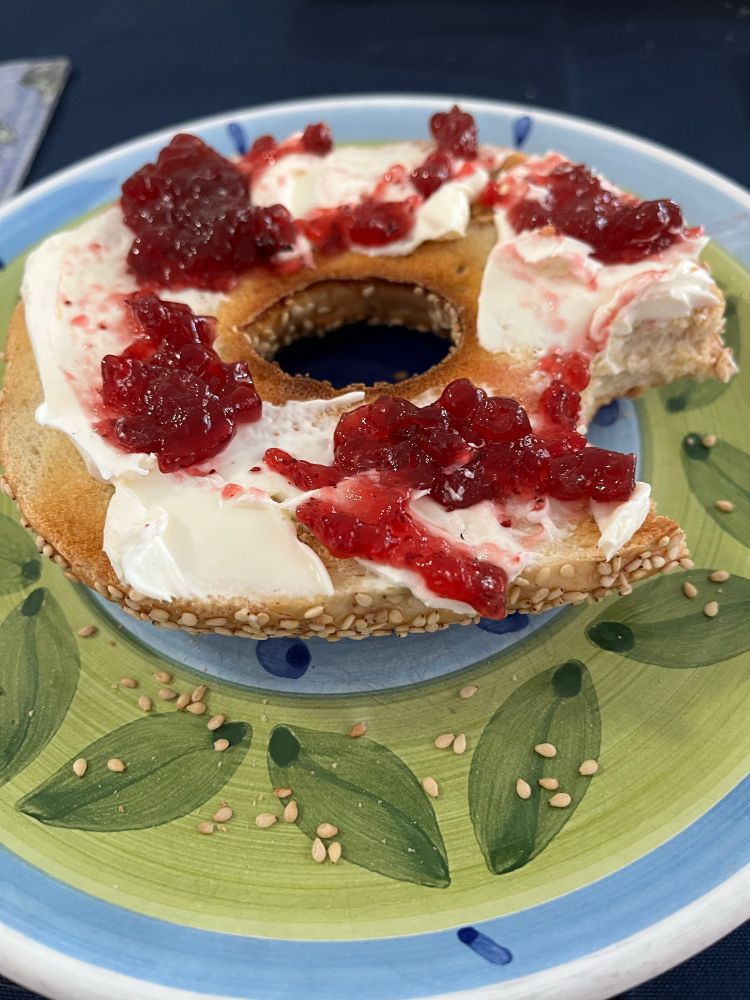 Sesame bagel with cream cheese and lingonberry sauce. 