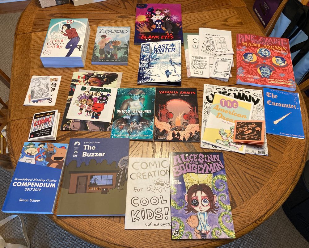 A bunch of comics arrayed on a wood grain table