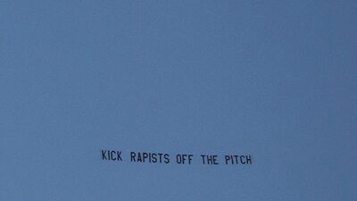 A banner that says “kick rapists off the pitch”