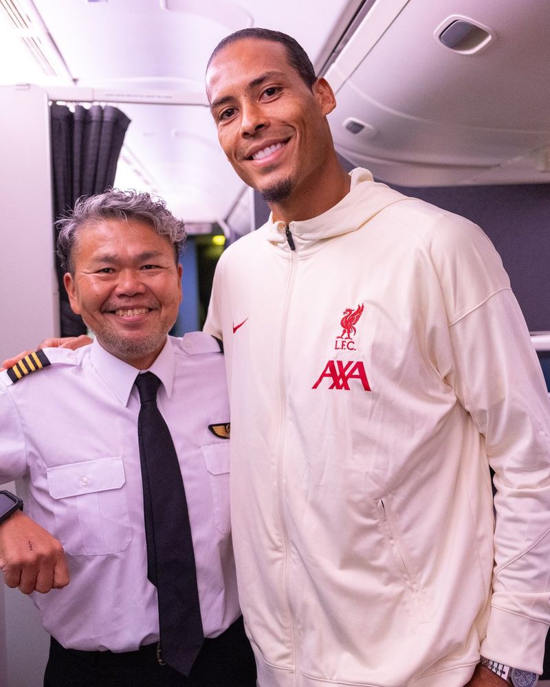 Virgil van Dijk and the Japan Airlines captain pose for a photograph on board the plane.