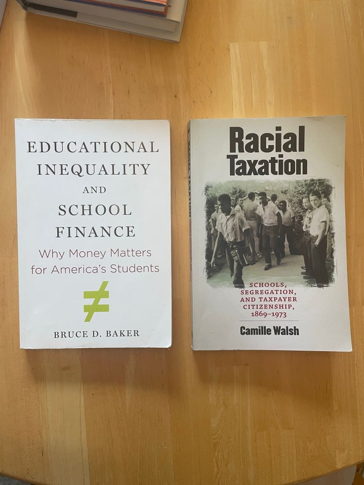 A picture of two books on a kitchen table. The first is “Educational Inequality and School Finance: Why Money Matters for America’s Students,” by Prof. Bruce D. Baker. The second is “Racial Taxation: Schools, Segregation, and Taxpayer Citizenship, 1869-1973,” by Prof. Camille Walsh. 