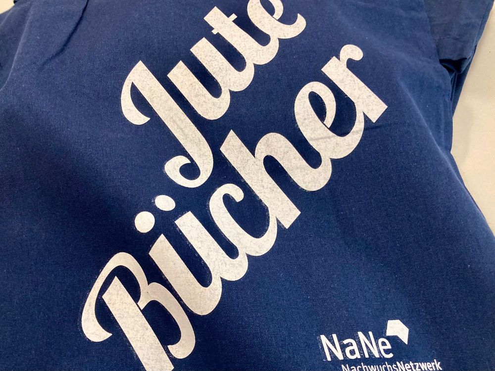 Ein blauer Stoffbeutel mit dem Schriftzug "Jute Bücher"