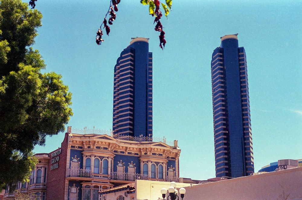 A film photo of two tall skyscrapers behind the Horton Grand Hotel in San Diego. 