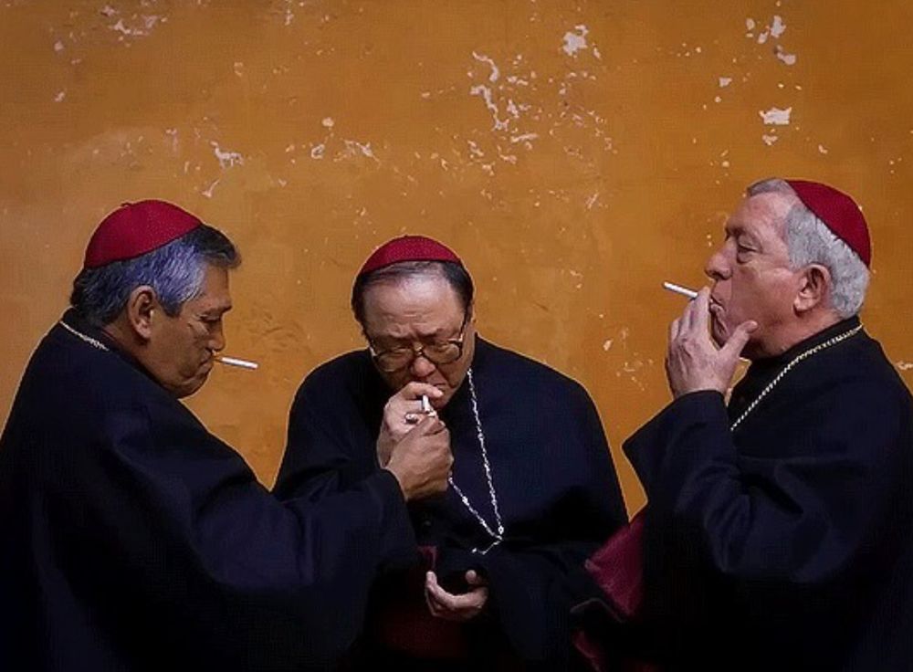 Three red-hatted cardinals smoke cigarettes.
