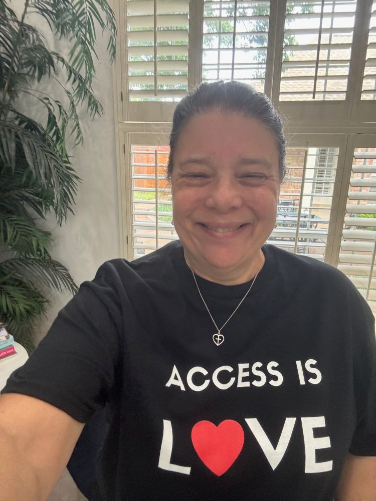 Glenda wearing her Access is Love shirt.  Black shirt with bold white lettering. The o in love has been replaced with a heart.