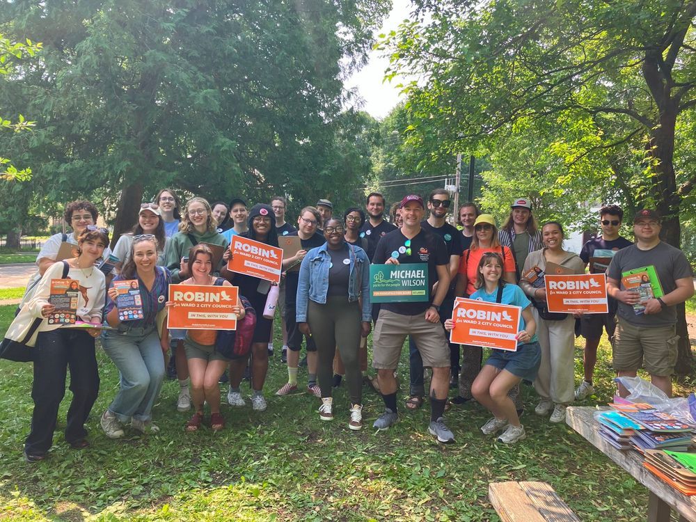 Large group of volunteers with Robin Wonsley and Michael Wilson holding campaign signs 