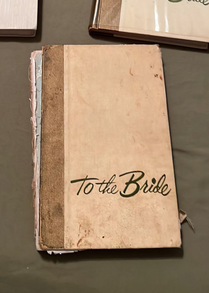 An old, well-used cookbook titled "To the Bride." The cover is stained and torn off. 