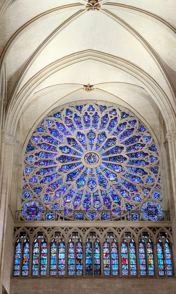 The south transept Rose window of Notre Dame de Paris, in clear blue tones against white stone.