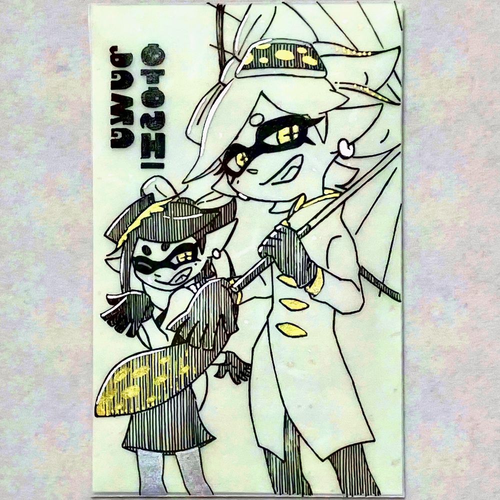 スプラ3ヒーローモードのホタルとアオリの絵が描かれた、薄緑色のぽち袋の写真。右手前にいるホタルは左手で番傘を差していて、左奥に顔だけこちらへ向けたアオリがいる構図。ホタルは右手で、アオリは両手で、シオカラーズの手首から先を垂らすポーズを取っている。黒い線画で描かれており、黒い部分は黒の縦線で埋めているが、インクリングの隈取りだけは隙間なく塗り潰してある。黄色や銀色の部分には、金と銀のボールペンで色を乗せてある。左上に、イカ語の文字で「OTOSHIDAMA」と書いてある