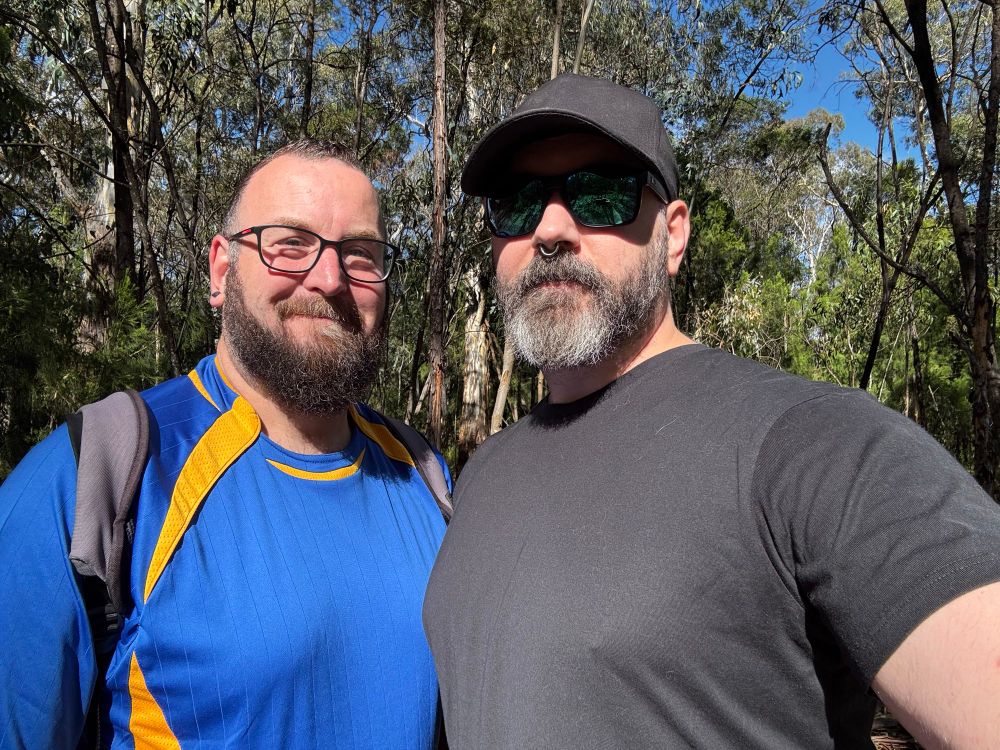 Two bearded men in the Australian wilderness posing for a selfie 