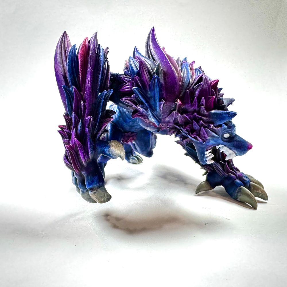 Dungeons and dragons wolf miniature painted in blues, purples and magenta tones. 