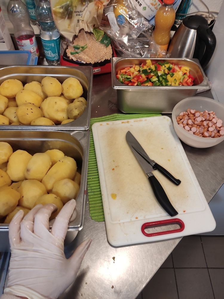 küche - pellkartoffeln, gemüse, würstchen, schneidebrett und messer.