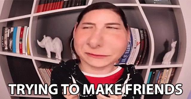 a woman is making a funny face while standing in front of a bookshelf .