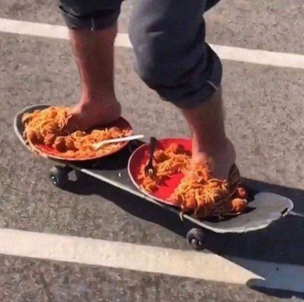 bare feet on tope of two plates of spaghetti riding a skateboard