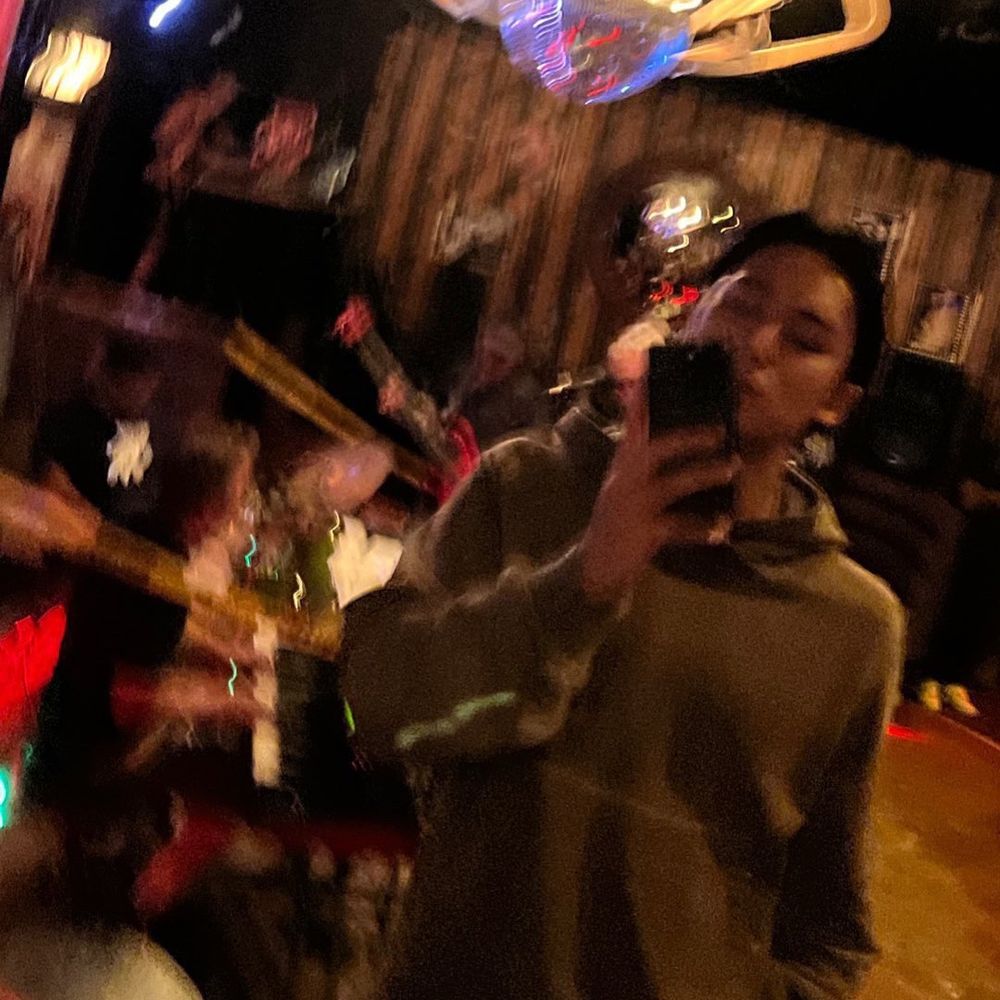 어둑한 곳에서 후디를 입은 민규의 초점 흔들린 거울 셀카