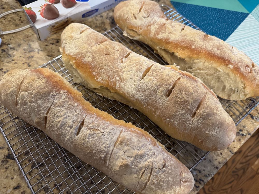 Three baguettes cooling on a wire rack 