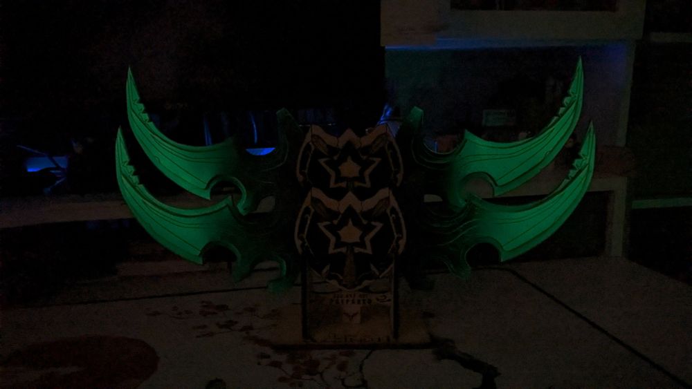 Foto con las Gujas de Illidan en soporte horizontal hechas en la oscuridad. Se puede ver cómo las hojas brillan en un color verde vil.