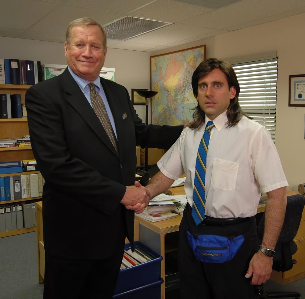 A businessman shaking hand of young Michael Scott. A screenshot from the office, where Michael looks stunned and confused.