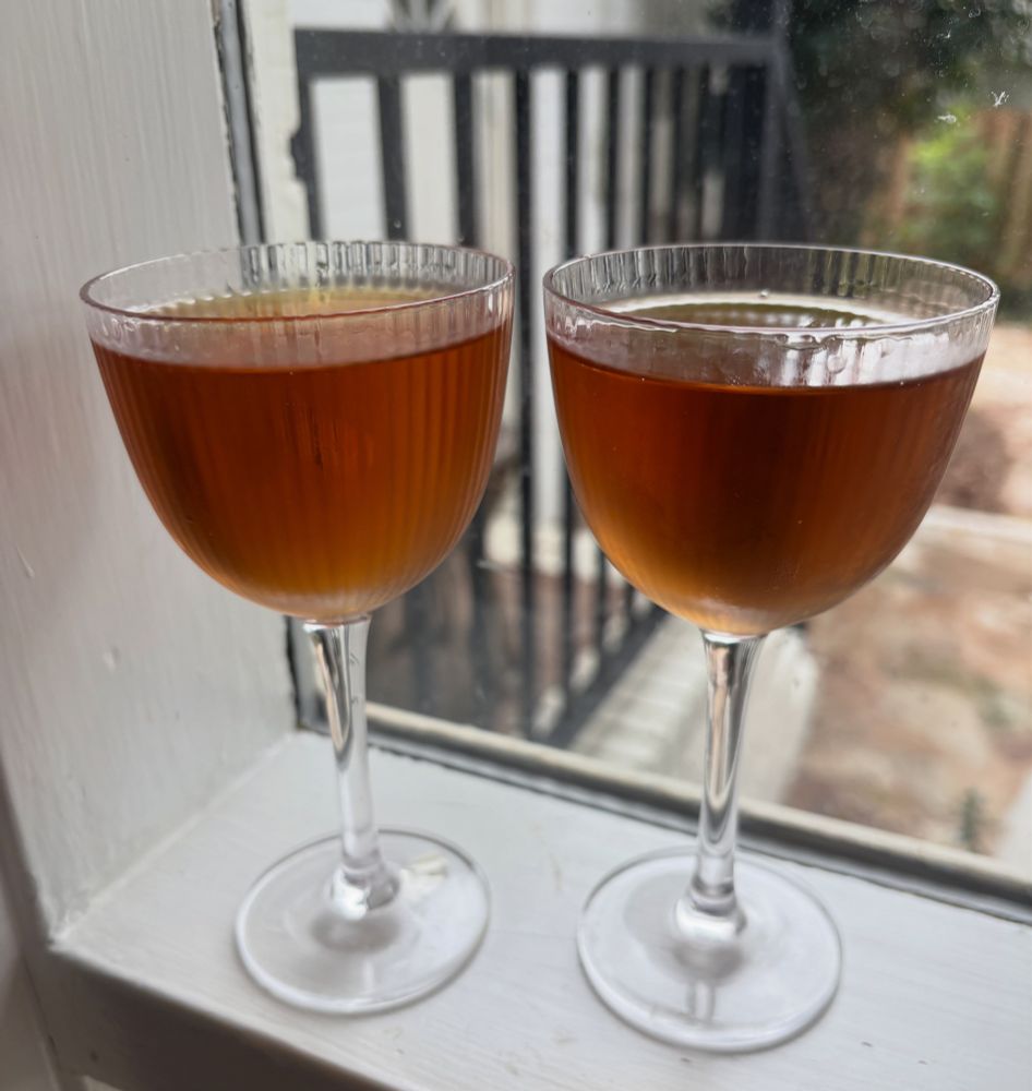 Two golden brown cocktails in nick&nora glasses