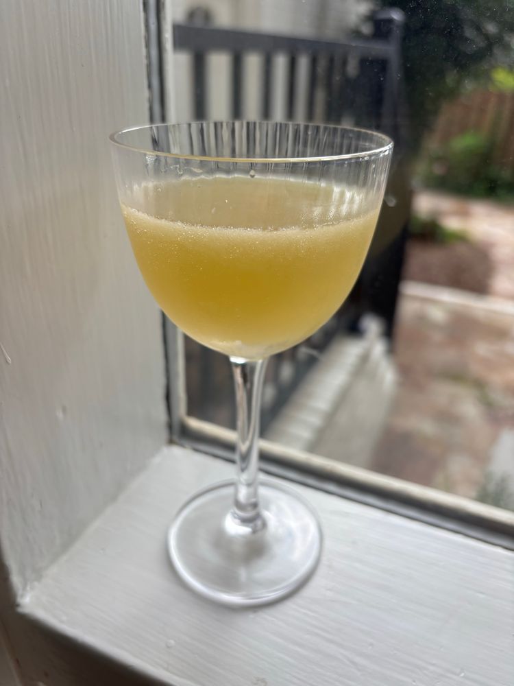 Yellow cocktail in a Nick & Nora glass 