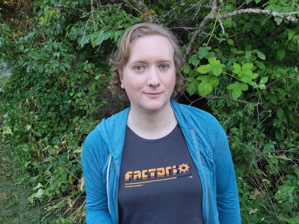 Zoe with a Factorio t-shirt under a blue hoodie.