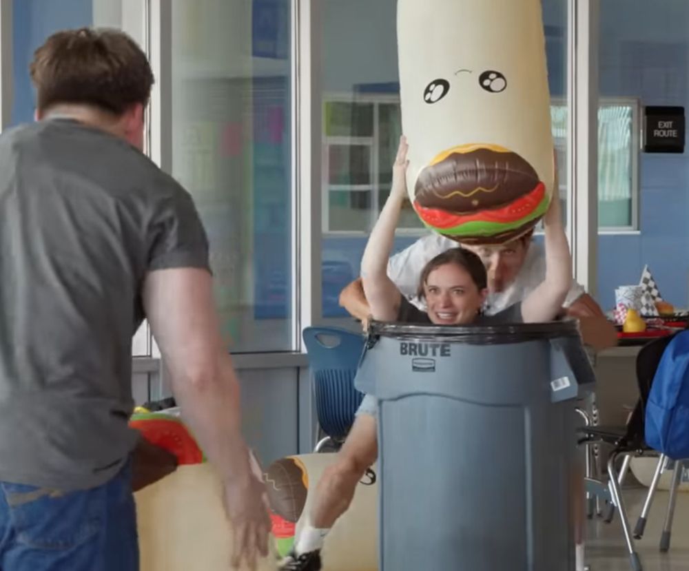 Angela holding a burrito being driven by Chanse, while Shayne stares flabbergasted