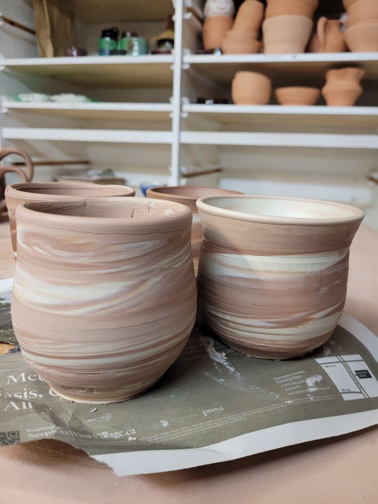 Some mug forms, pre handle attach, with swirled clay (white and red)