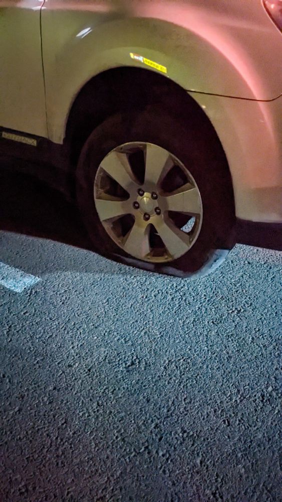 a car with a very, very flat tire on the passenger side 