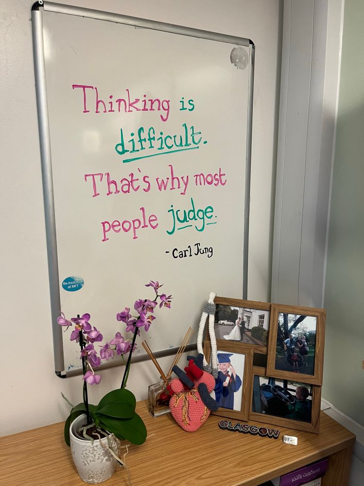 Whiteboard with a quote saying “Thinking is difficult. That’s why most people judge”.