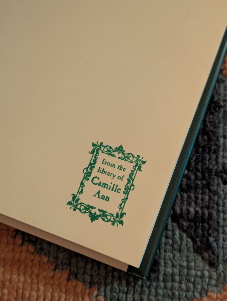 Inside the cover of a novel with a stamp that read "from the library of Camille Ann"