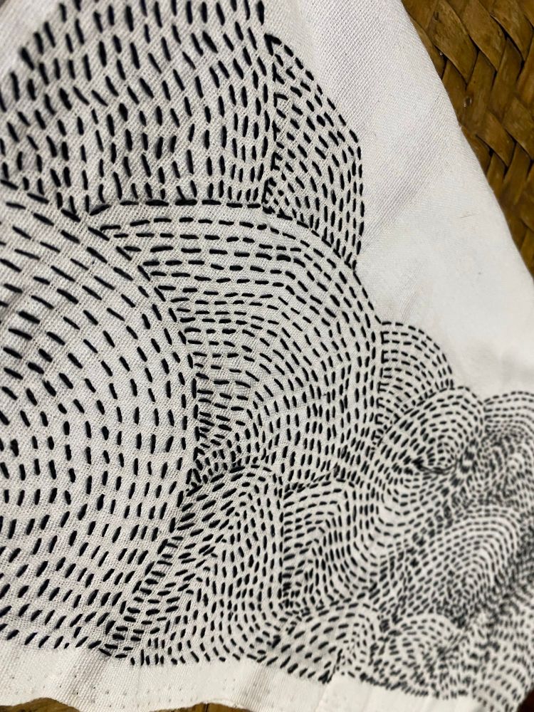 Bordado abstrato em ponto alinhavo formando ondas, círculos e espirais. Linha preta sob Tecido 100% algodão branco