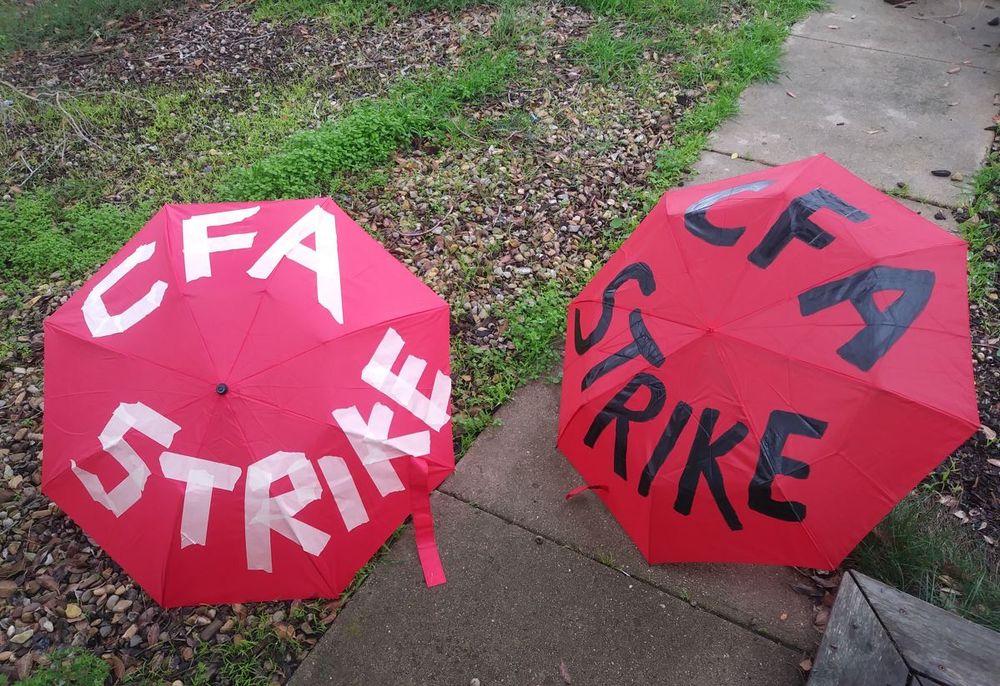 Red umbrellas decorated with "CFA STRIKE" lettering