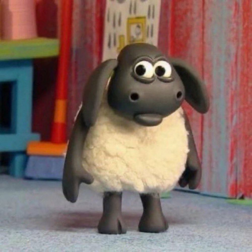 A 3d animated sheep character with pale wool and a black face and limbs has a puzzled expression on their face.