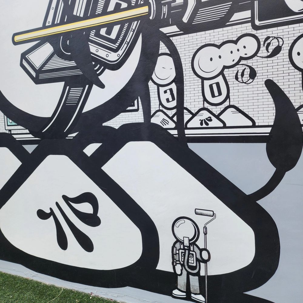 Close-up of a mural showing a character dressed in a space suit holding a paint roller.