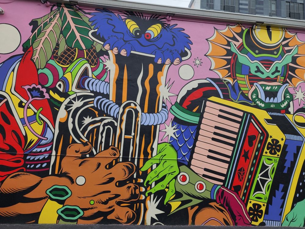 A close-up of a mural showing two monster musicians