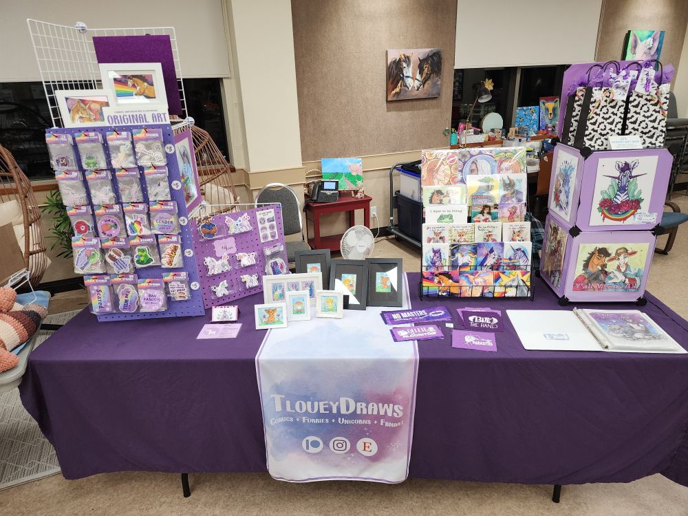 Photo of my market table covered in my art for sale.