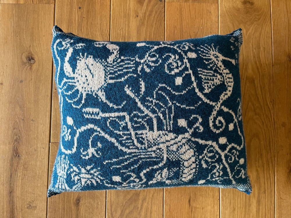 Front of the cushion showing the detailed motifs of prawn, crab and seahorse tangled in seaweed. 