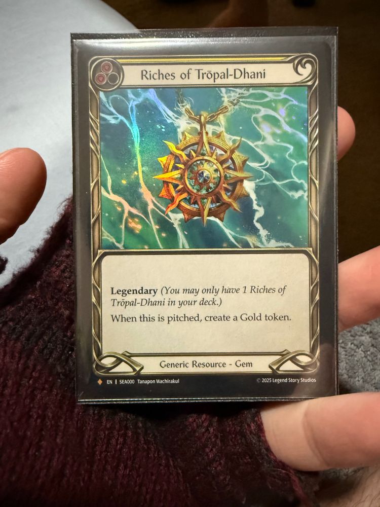 Multi-sleeved Fabled-Rare “Riches of Trōpal-Dhani” from the Flesh and Blood set “High Seas”

A yellow (2-resource) Legendary Generic Resource - Gem that when pitched, creates a Gold token.