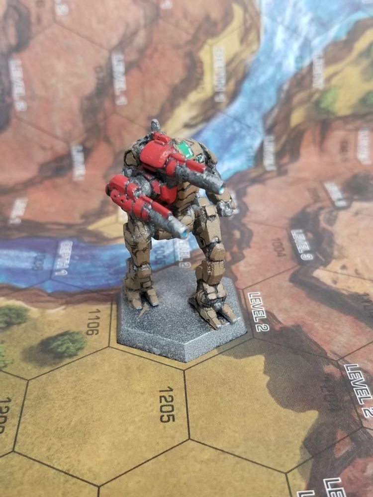 Front view of a Starslayer from Battletech, in army brown with red on the torso mounted Laser and Laser arm. Angled so that the lasers are toward the camera