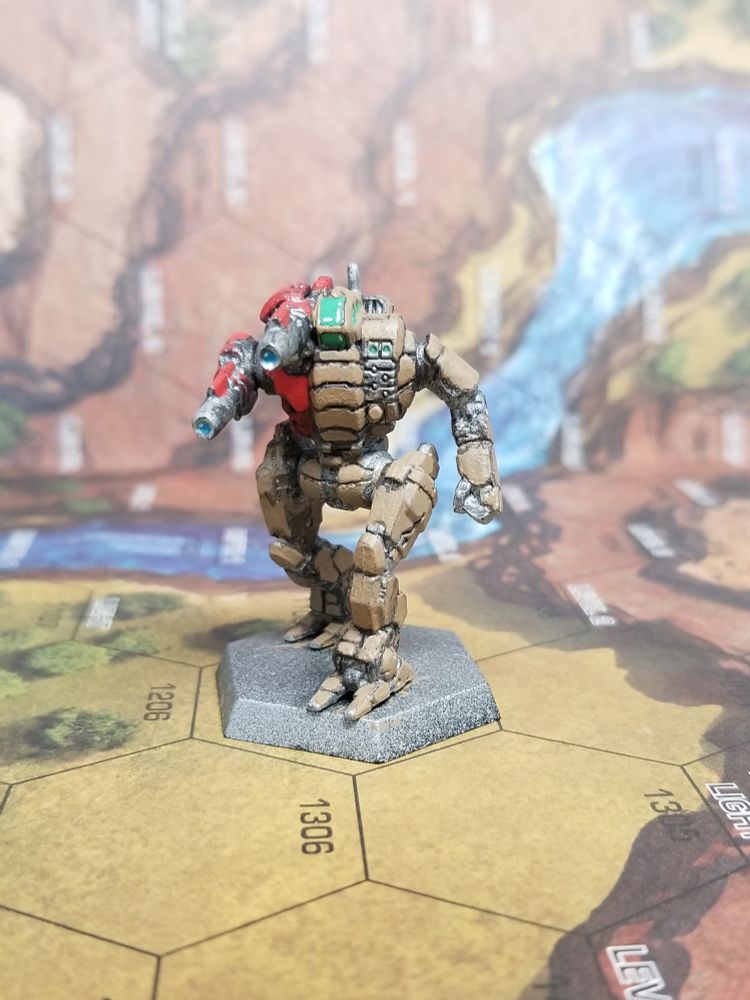 Front view of a Starslayer from Battletech, in army brown with red on the torso mounted Laser and Laser arm, angled so that the specular detail on the laser lenses is visible 