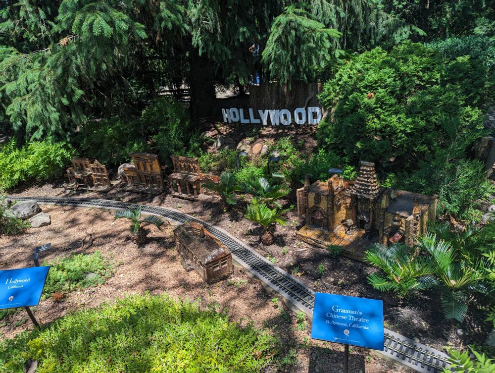 Miniature Hollywood, CA, along the model railroad tracks, complete with tiny living "palm trees" 