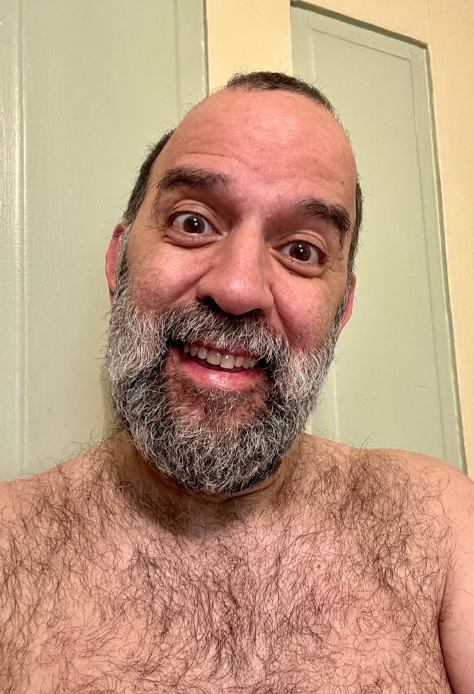 Bearded man shirtless & smiling 