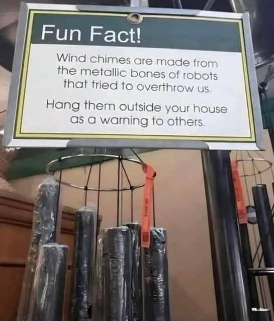 A sign advertising wind chimes that says, "Wind chims are made from the metallic bones of robots that tried to overthrow us. Hang them outside your house as a warning to others."