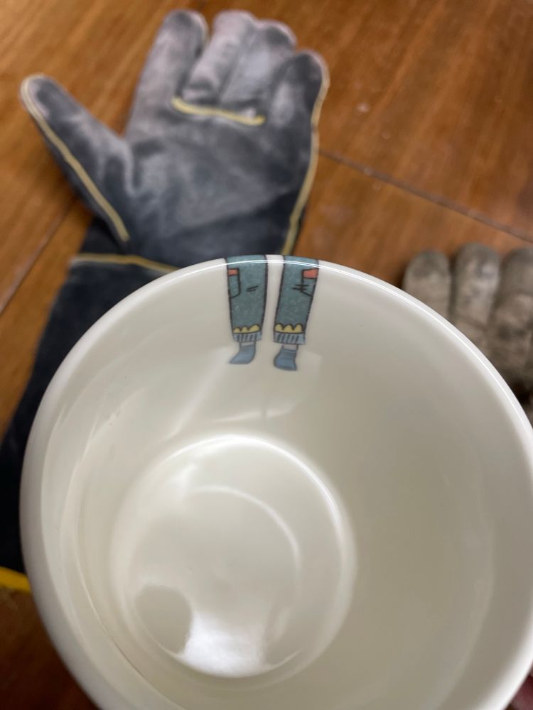 Info white mug, two legs dangle down