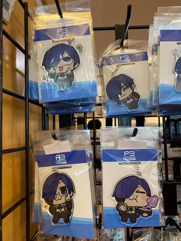 Four various keychains of the persona 3 protagonist drawing in the style of Pop Team Epic 