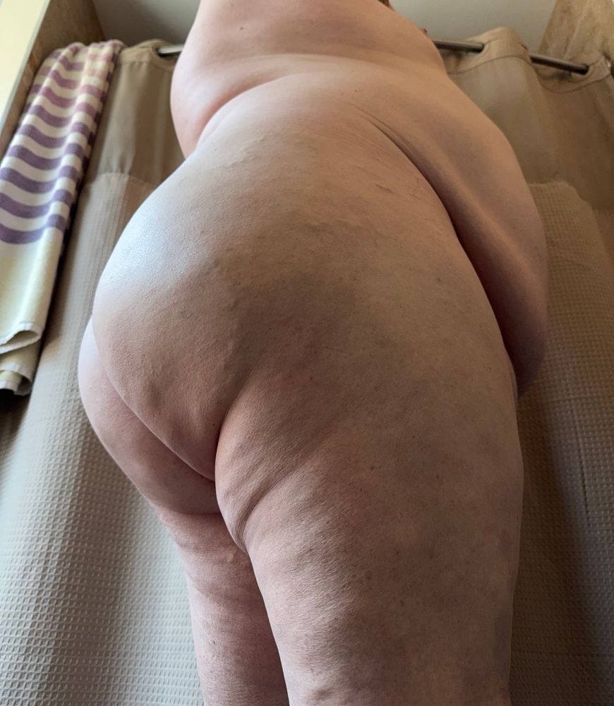 A big fat smooth ass from the side with a view of belly and boob
