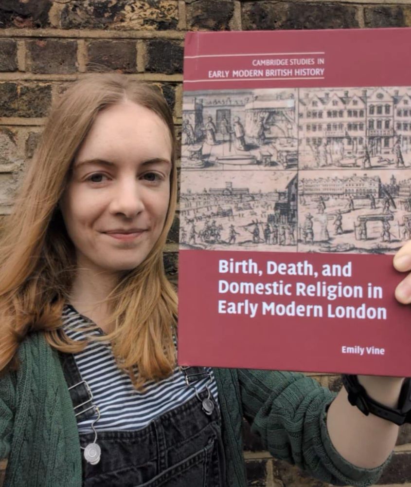 A photo of the author holding up a copy of her book, which has a red cover.