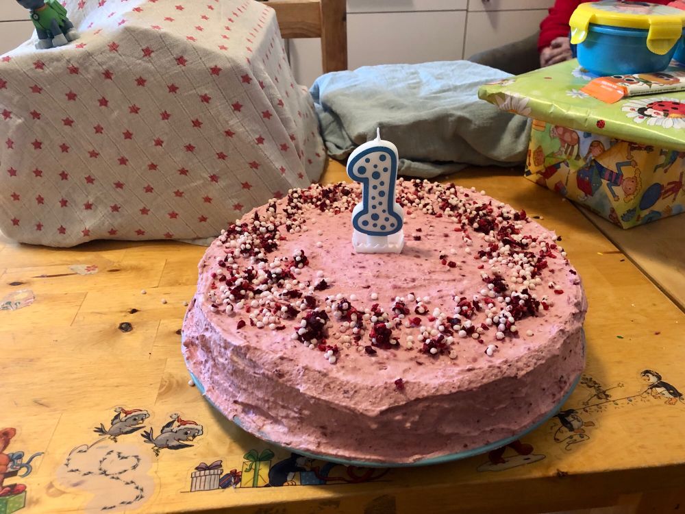 Rosa Torte mit einer Kerze in Form einer Eins